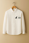 White shirt with a dinosaur and cactus design on a beige background