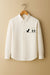White shirt with a dinosaur and cactus design on a beige background